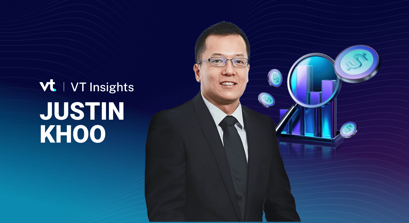 Portrait of Justin Khoo in a suit beside the VT Insights branding on a blue gradient background with a digital graphs/coins graphic to the right; business profile feel.