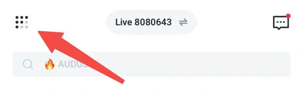 سربرگ با آیکون منوی شبکهای در سمت چپ، نشان «Live 8080643» در مرکز و آیکون چت در سمت راست با نقطه اعلان قرمز؛ در زیر آن نوار جستجویی با عبارت «🔥 AUDUS» دیده میشود؛ یک فلش قرمز روی آیکون سمت چپ قرار دارد.